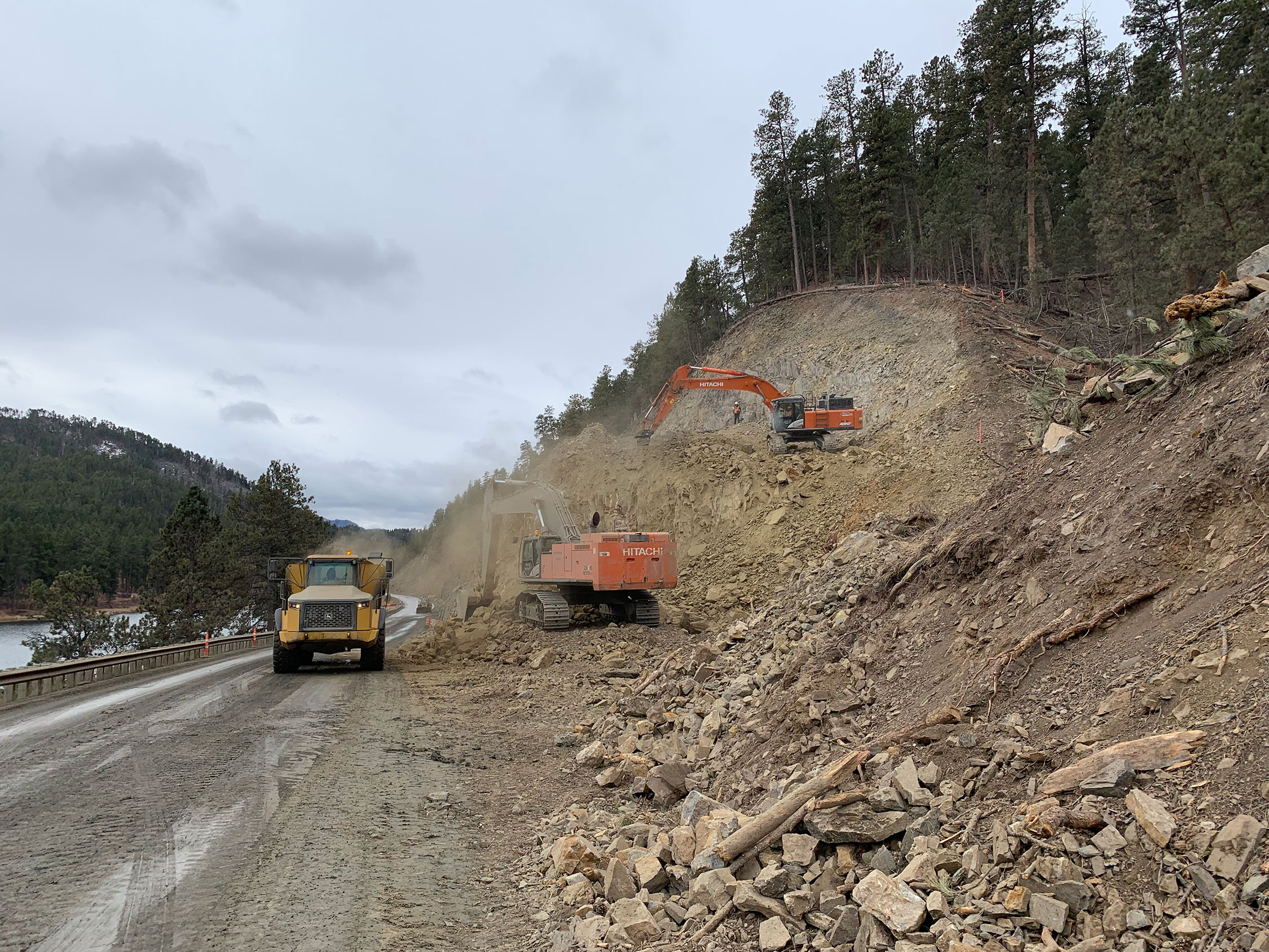 Excavator doing work clearing trees and logging on a hill