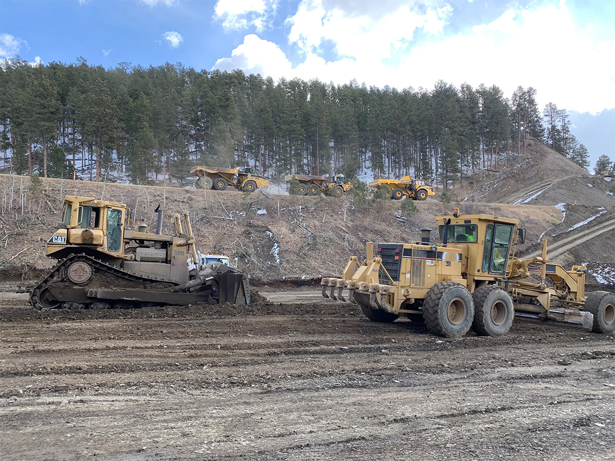 Multiple construction vehicles working on future roadway.