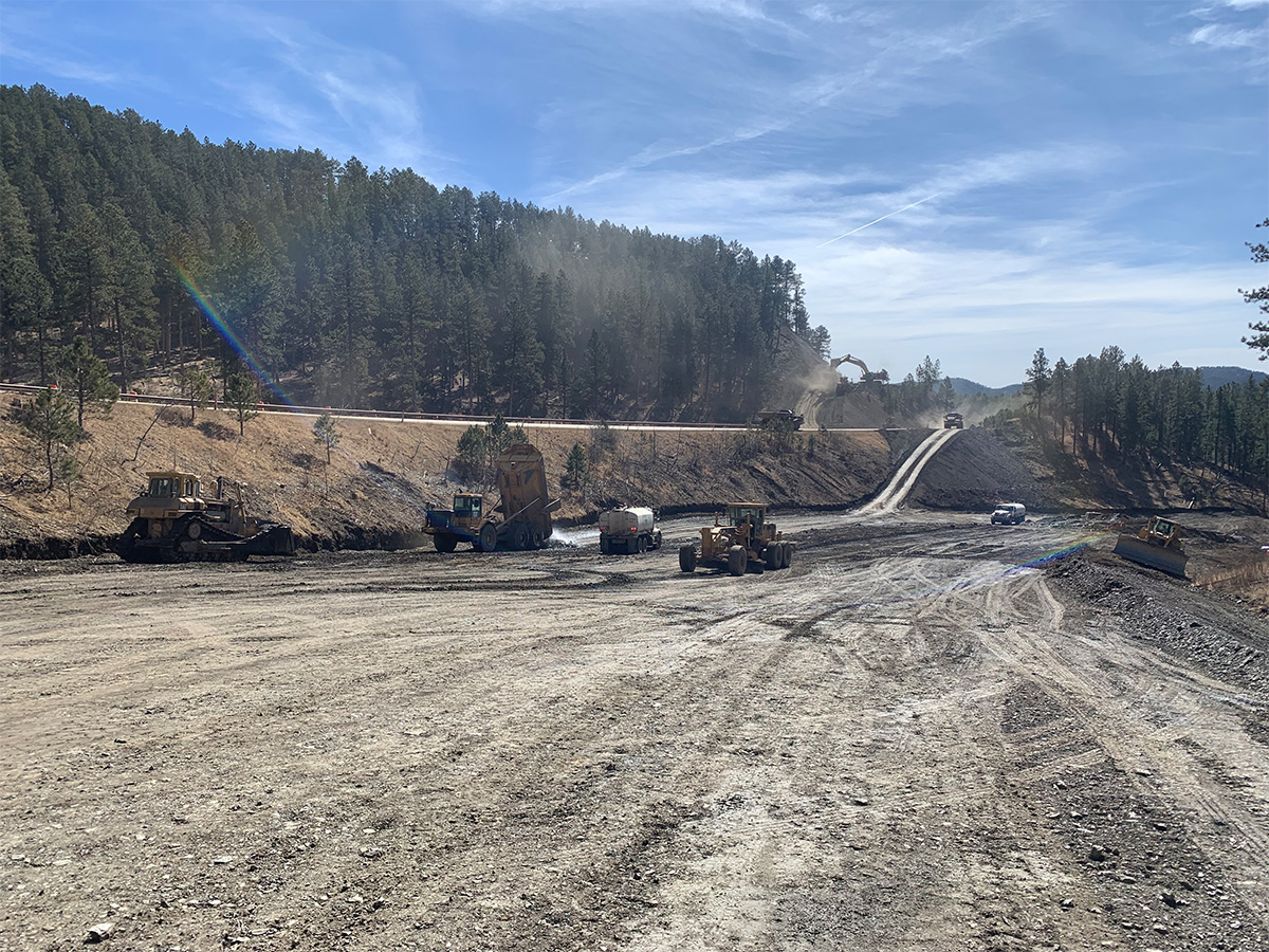 Multiple construction vehicles working on future roadway.